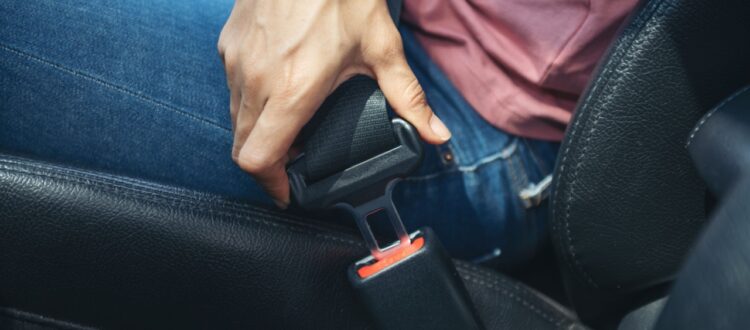 A man fastens his car seatbelt