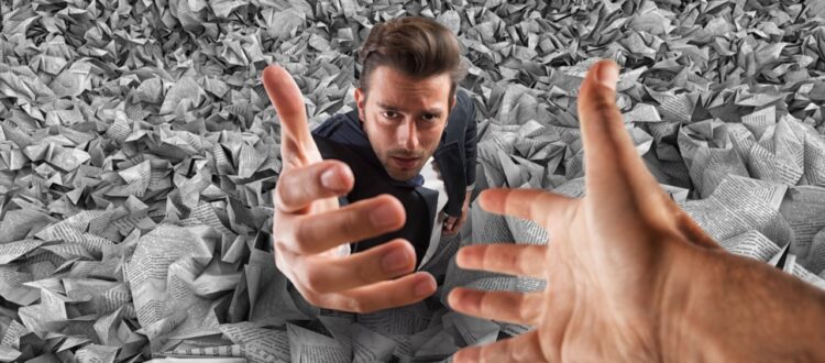 Businessman sinking into pile of paper